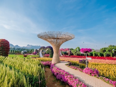 Lavish outdoor garden with mounds of colorful flowers with unique wooden structures.