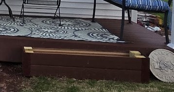 Long wooden outdoor planter next to a deck