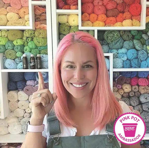 Wave Pink Pot Ambassador for December 2022 Erica in her rainbow-colored yarn room