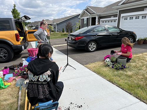  A crew films a woman planting flowers