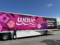 Person celebrating in front of the Wave Petunias Semi Truck