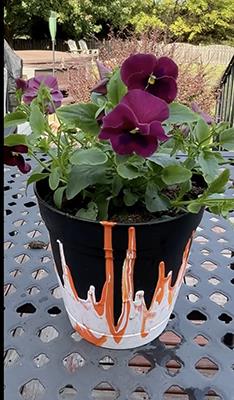 Flower pot with painted flames and purple pansies